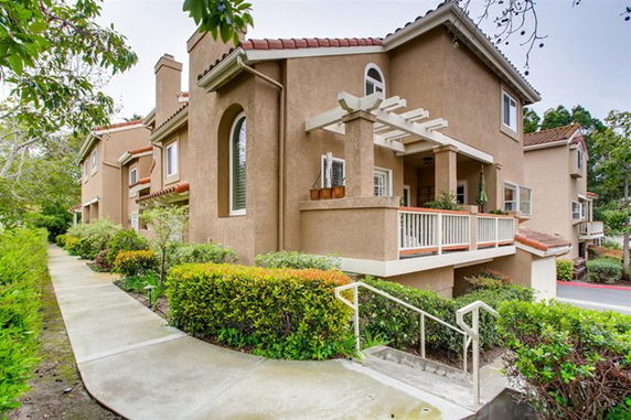 Front view of a two-story house with a porch and arched window.