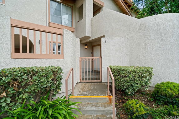 Front view of a two-story building entrance with a gated doorway.