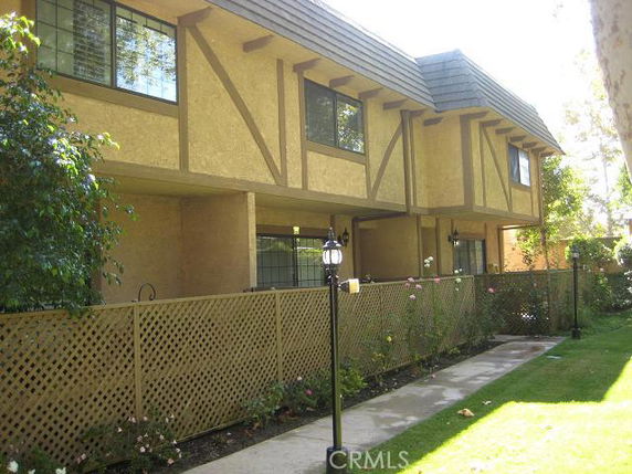 Front view of a two-story building with lattice fence and textured walls.