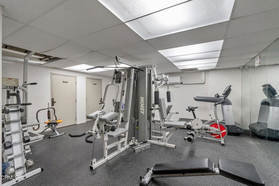 Indoor gym with various exercise equipment and machines.