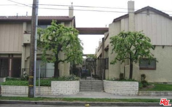 Front view of a multi-story residential building with a gated entrance.