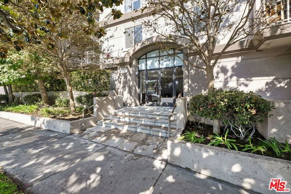 Front view of a building with glass entrance and stairs