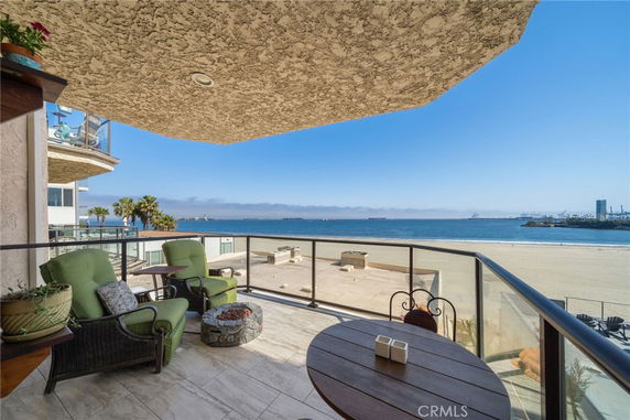 Balcony view overlooking a sandy beach with a distant shoreline.