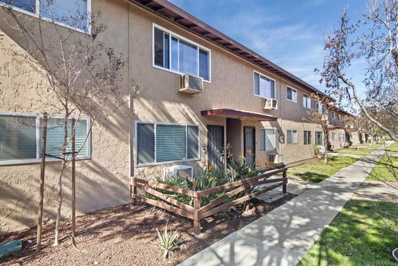 Front view of a two-story apartment building with multiple windows and entryways.