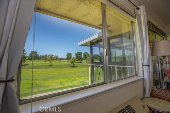 View from inside a building looking out over a green lawn and trees.