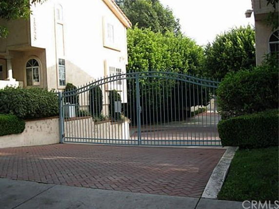 Front view of a two-story house with an iron gate.