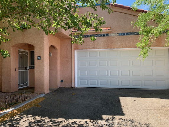 Front view of a house with a double garage and an arched entryway.