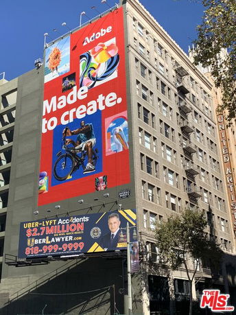 Front view of a multi-story building with large advertisements displayed on its facade.