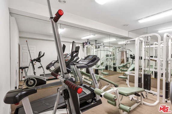 Indoor gym area with exercise equipment including treadmills and weight machines.