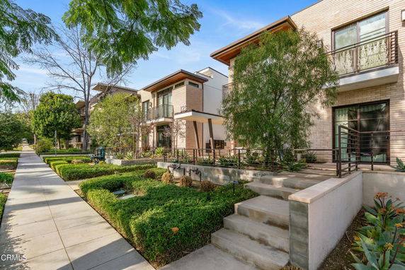 Front view of a modern two-story house with landscaped garden.