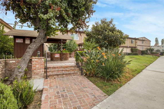 Front view of a house with brick walkway and garden.