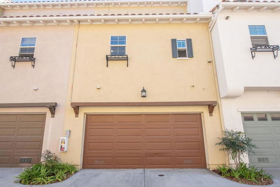 Front view of a townhouse with a double garage and two upper windows.