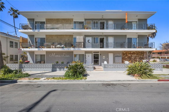 Front view of a multi-story apartment building with balconies.