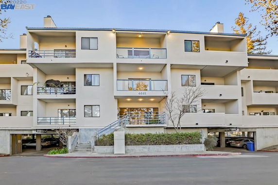 Front view of a multi-story apartment building with balconies and stair access.