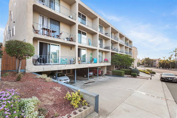 Front view of a multi-story apartment building with balconies.