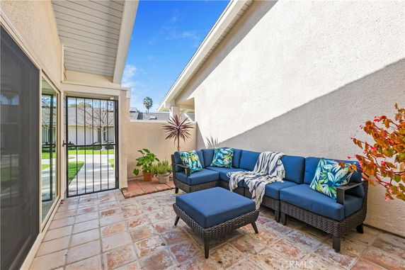 Outdoor patio area with blue cushioned seating adjacent to a building.