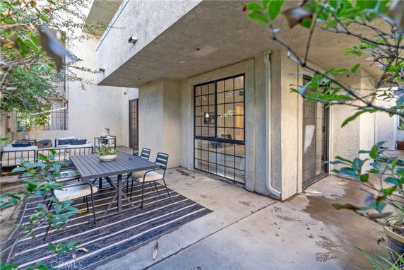 Front view of a house with large windows and outdoor seating area.