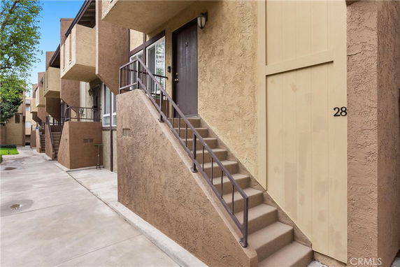 Front view of a multi-level residential building with staircase entry.
