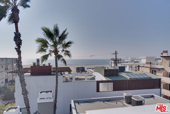 Wide-angle view of rooftops and the ocean in the background.