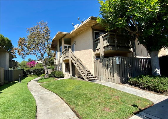 Front view of a two-story residential building with stairs leading to the upper level.
