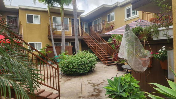 Front view of a multi-story residential building with staircases and balconies.
