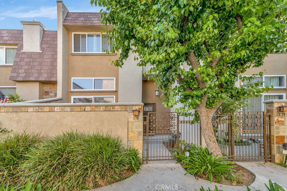 Front view of a multi-story townhouse with a gated entrance.