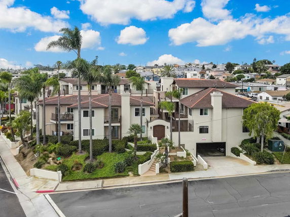 Front view of a multi-story residential building with a gated entrance.