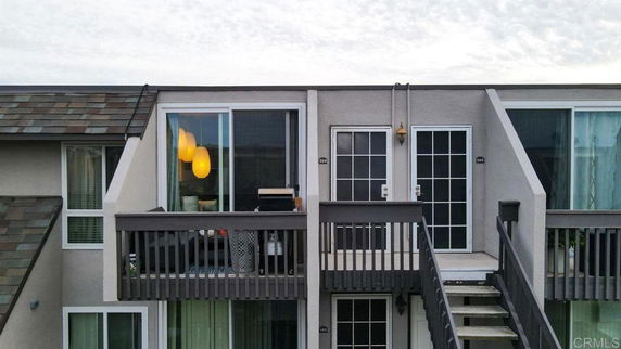 Front view of a multi-story building with balconies and large windows.