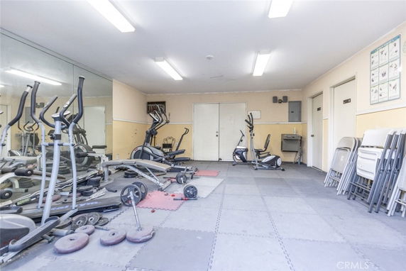 Indoor gym area with exercise equipment and folding chairs.