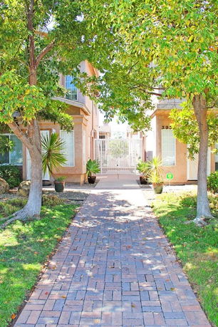 Front view of a house with a pathway leading to the entrance, surrounded by trees.
