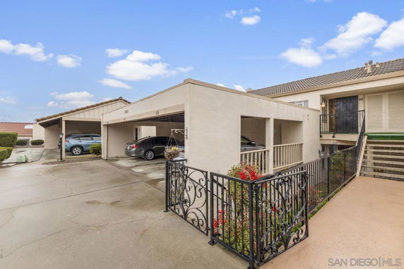 Covered parking area in front of a building entrance.