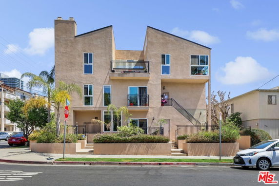 Front view of a multi-story house with a unique angular roof design and multiple balconies.