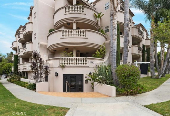 Front view of a multi-story residential building with curved balconies.