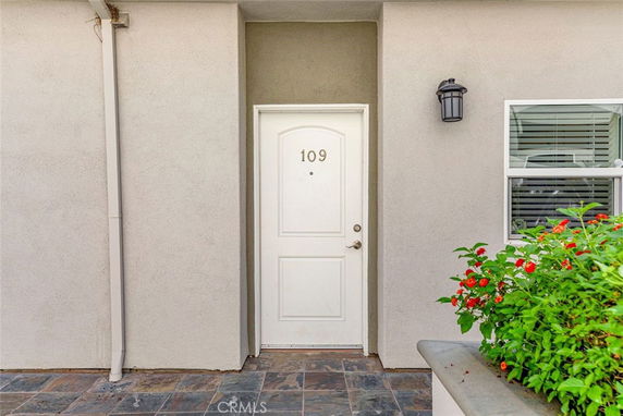 Front view of a house with a white door numbered 109 and a small window beside it.