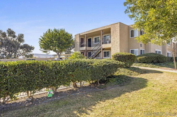 Front view of a two-story apartment building with outdoor stairway.
