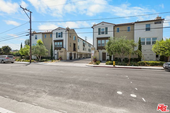 Front view of a multi-story residential building with garage entrances on the ground level.