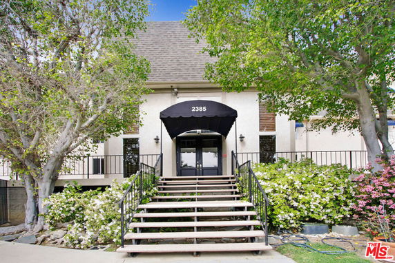 Front view of a building with an entrance canopy and staircase.
