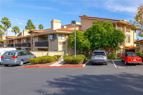 Outdoor parking area in front of a multi-story residential building.