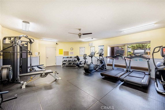 Indoor gym area with fitness equipment including treadmills and weights.