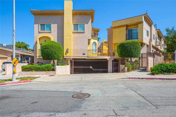 Front view of a multi-story residential building with a gated entrance.