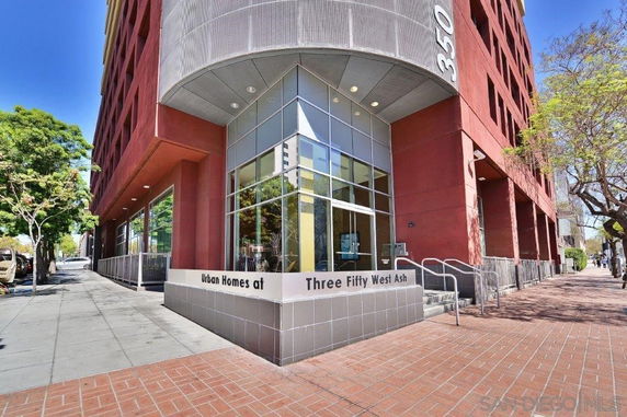 Front view of a multi-story building with large windows and a brick facade.