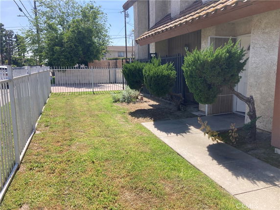 Front view of a house with a small lawn and paved walkway.