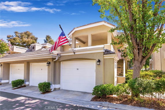 Front view of a two-story house with a double garage and an American flag.