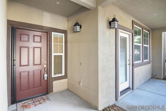Entrance area of a house with double doors and windows.