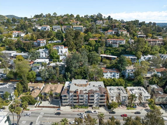 Panoramic view of a hilly area with multiple residential buildings and greenery.