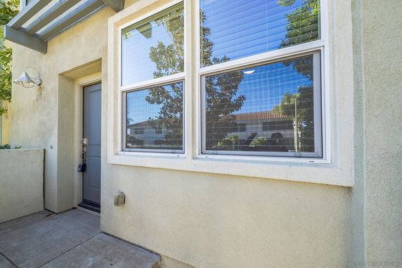 Front view of a building with a gray door and a large window.