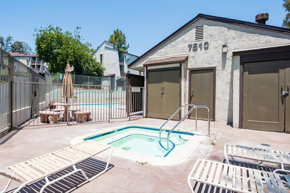 Outdoor swimming pool area with lounge chairs and a building marked with the number 7510.