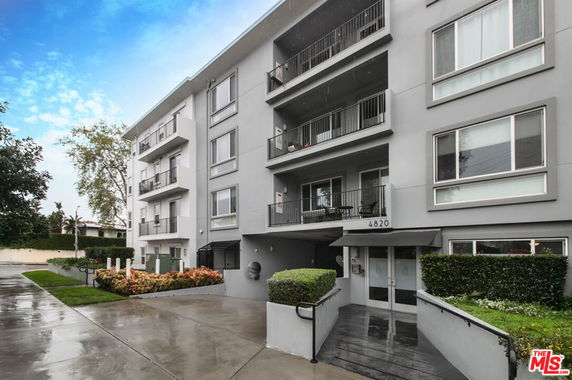 Front view of a multi-story apartment building with balconies.