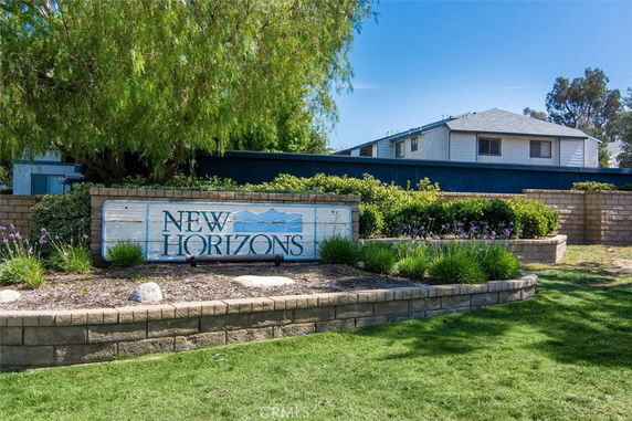 Front view of a residential building with a sign labeled 'New Horizons'.