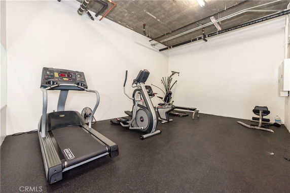 Indoor gym area with workout equipment including a treadmill and elliptical machines.